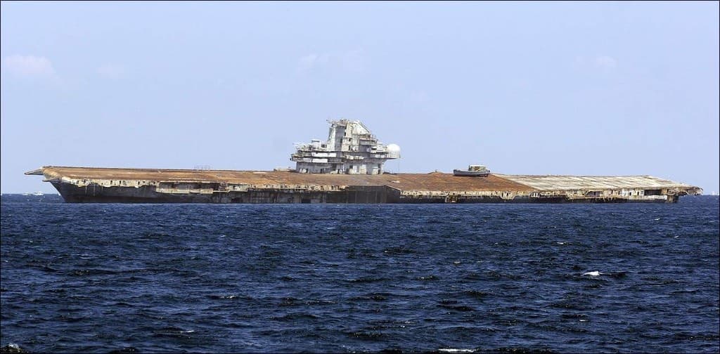 USS Oriskany afloat on open water, rusted flight deck and island intact