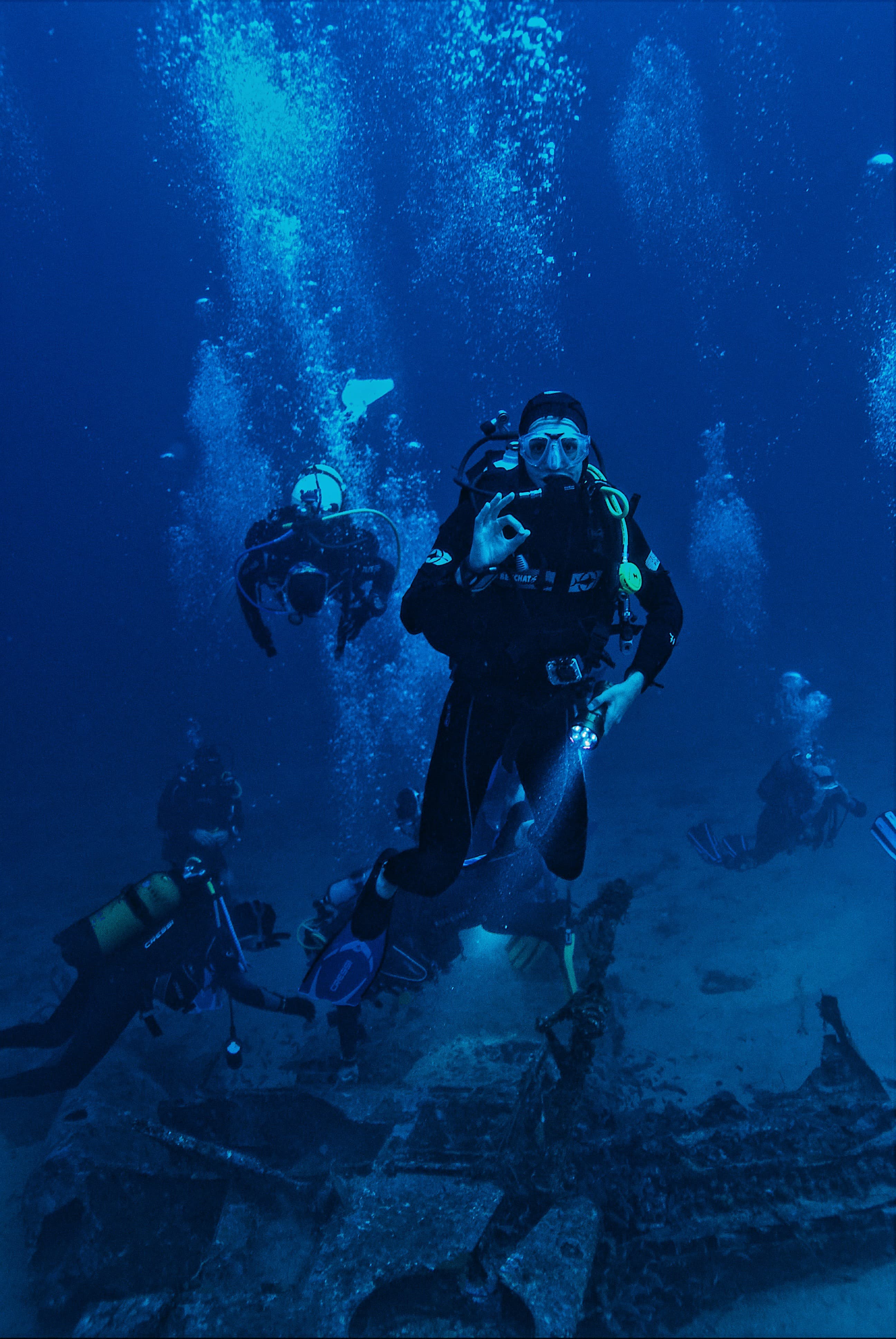Team on a wreck with a dive light