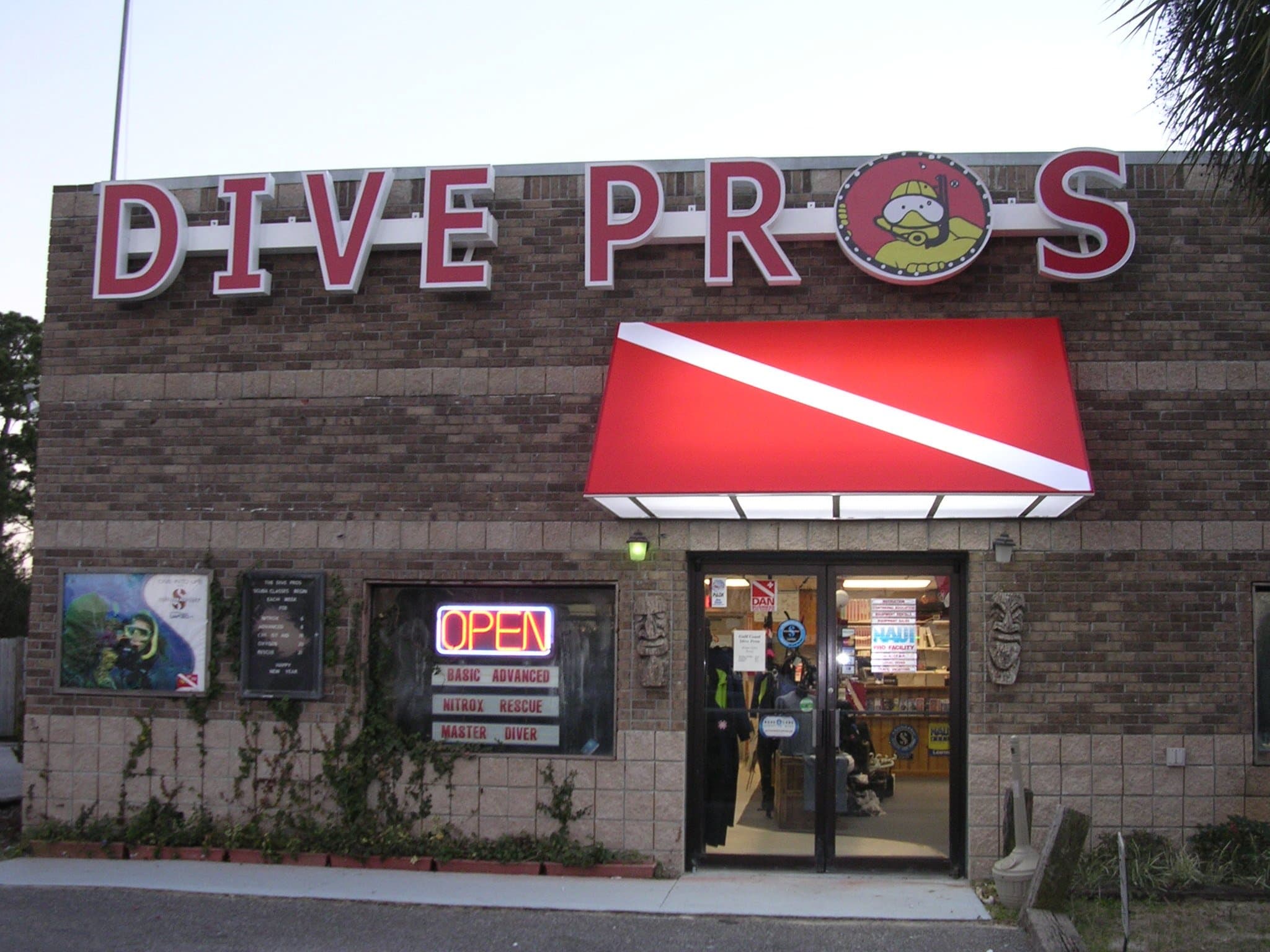 Dive Pros shopfront on W. Hwy. 98 in Pensacola: red awning, diver-down stripe, and OPEN sign