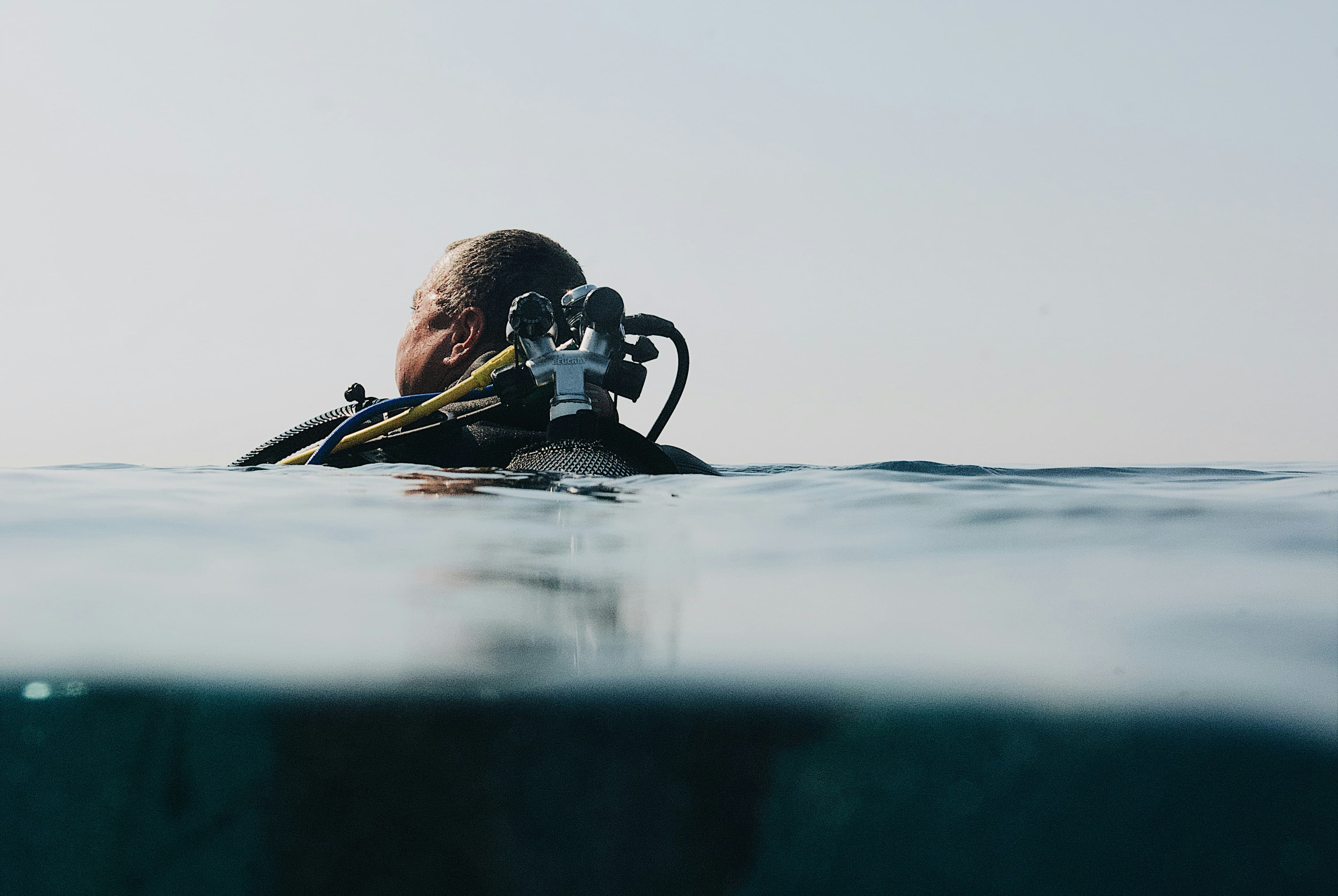 Diver at the surface with SCUBAPRO kit, split above and below the waterline